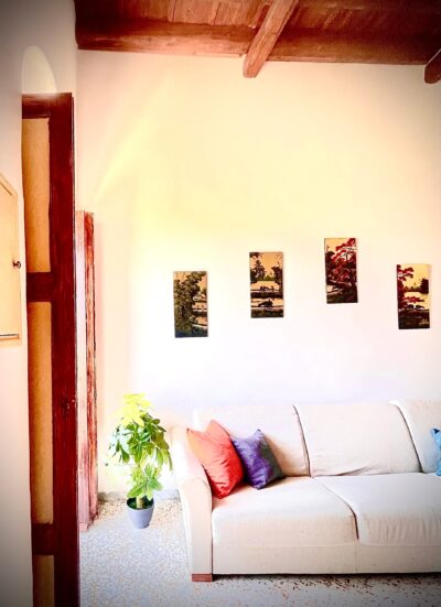 Soggiorno luminoso con divano bianco e pareti chiare nell'appartamento Comandante del Borgo.