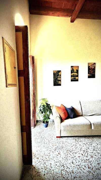 Accogliente soggiorno con divano e travi a vista nell'appartamento Comandante del Borgo a Bisceglie.